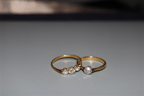 An 18ct and plat, solitaire diamond ring, size M/N, gross 2.5 grams and a yellow metal and three stone diamond ring.